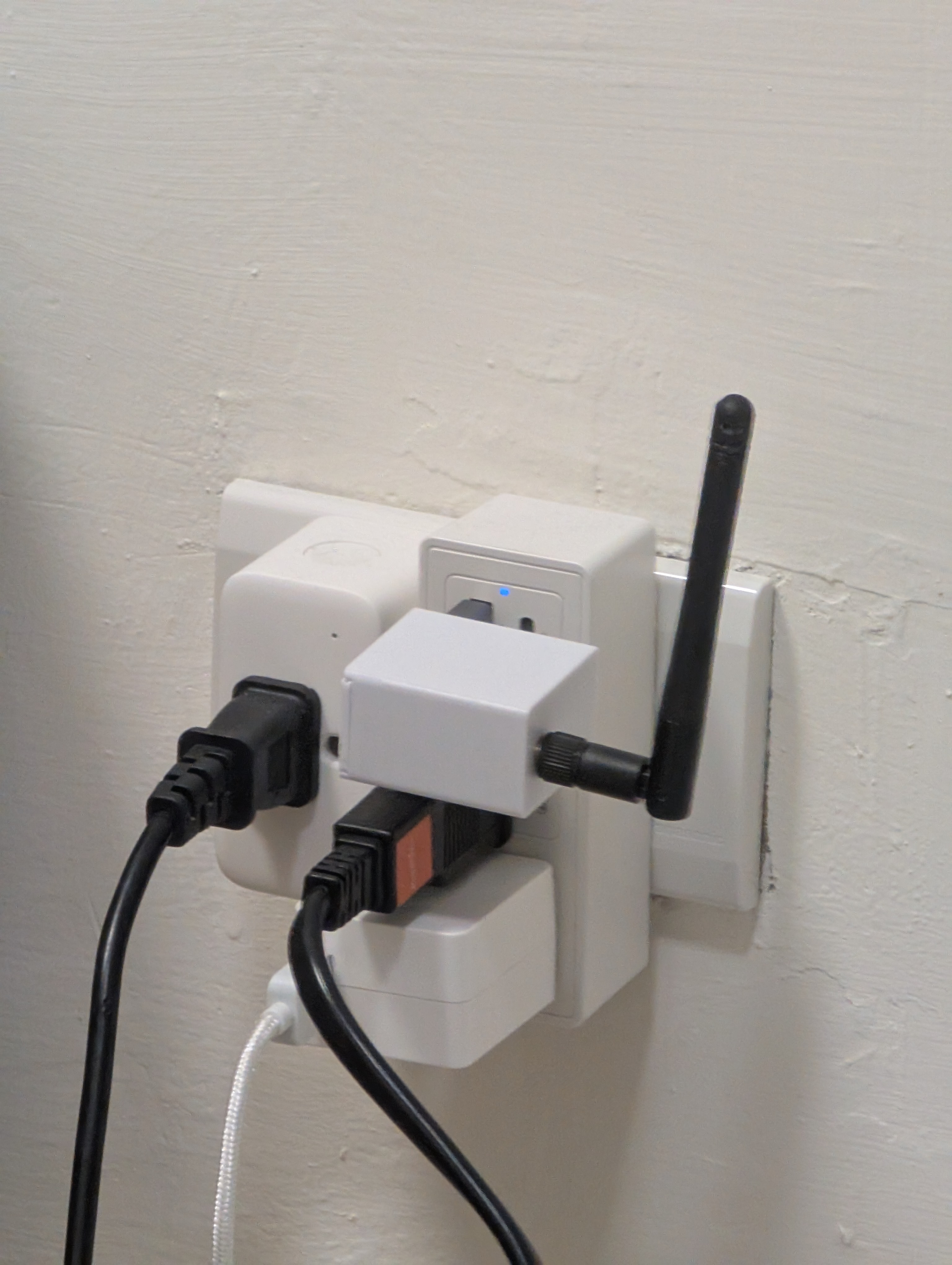 지금 모습: ESP32-C3와 CC1101이 동료가 3D 프린팅한 흰색 작은 케이스에 들어가 내 방 벽의 휴대폰 충전기에 꽂혀 있다. 검은 건 433MHz 안테나
